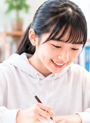ノートに向かって笑顔で勉強する生徒(JuKuOKA Instagram投稿より)